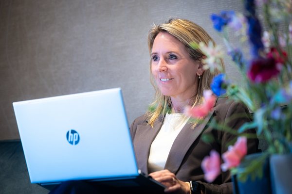 Laura lachend achter haar laptop